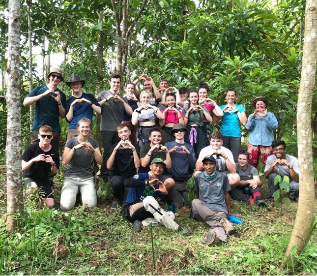 A group of secondary school students (male and female) somewhere in the woods. 