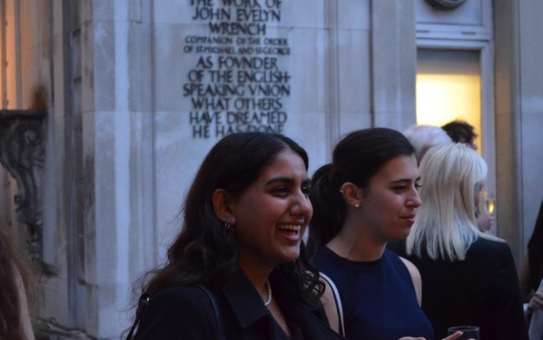 Two people smiling while leaving a building