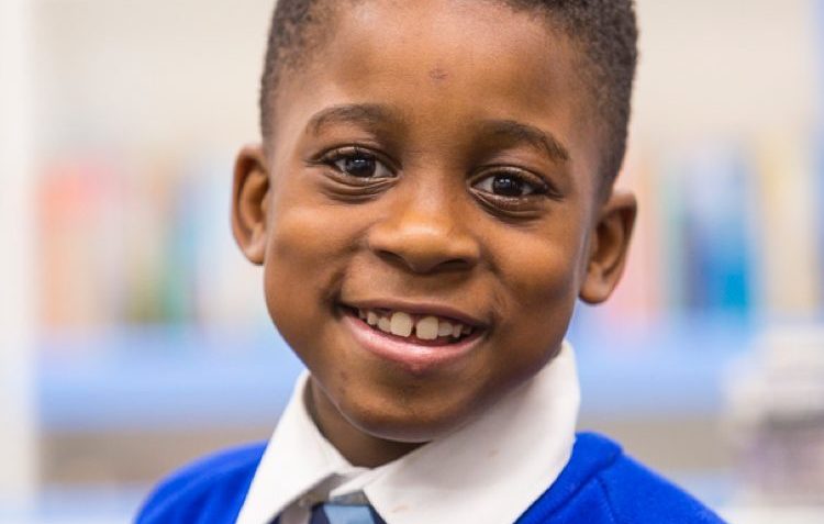 A photo of a young primary school boy smiling.