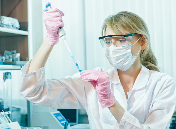 Female scientist uses pipette in a lab