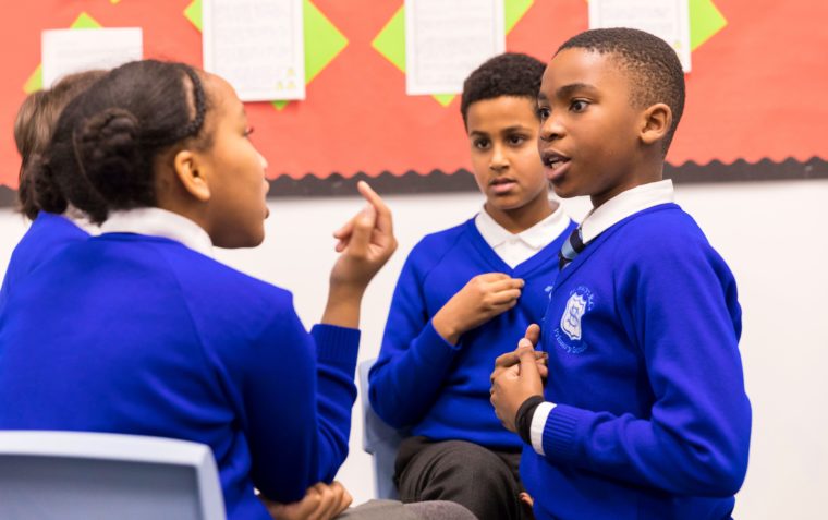 Four primary school pupils (two boys and two girls) are debating.