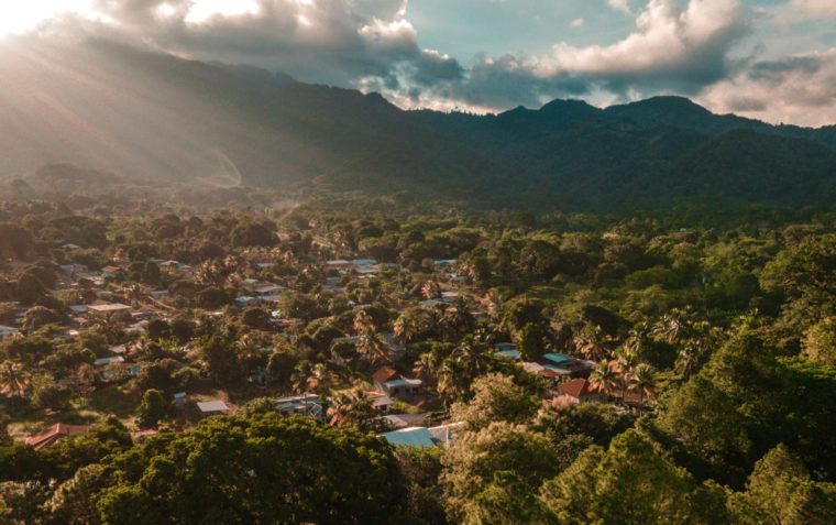 An aerial view photograph of a small community in Honduras with the mountain in the background