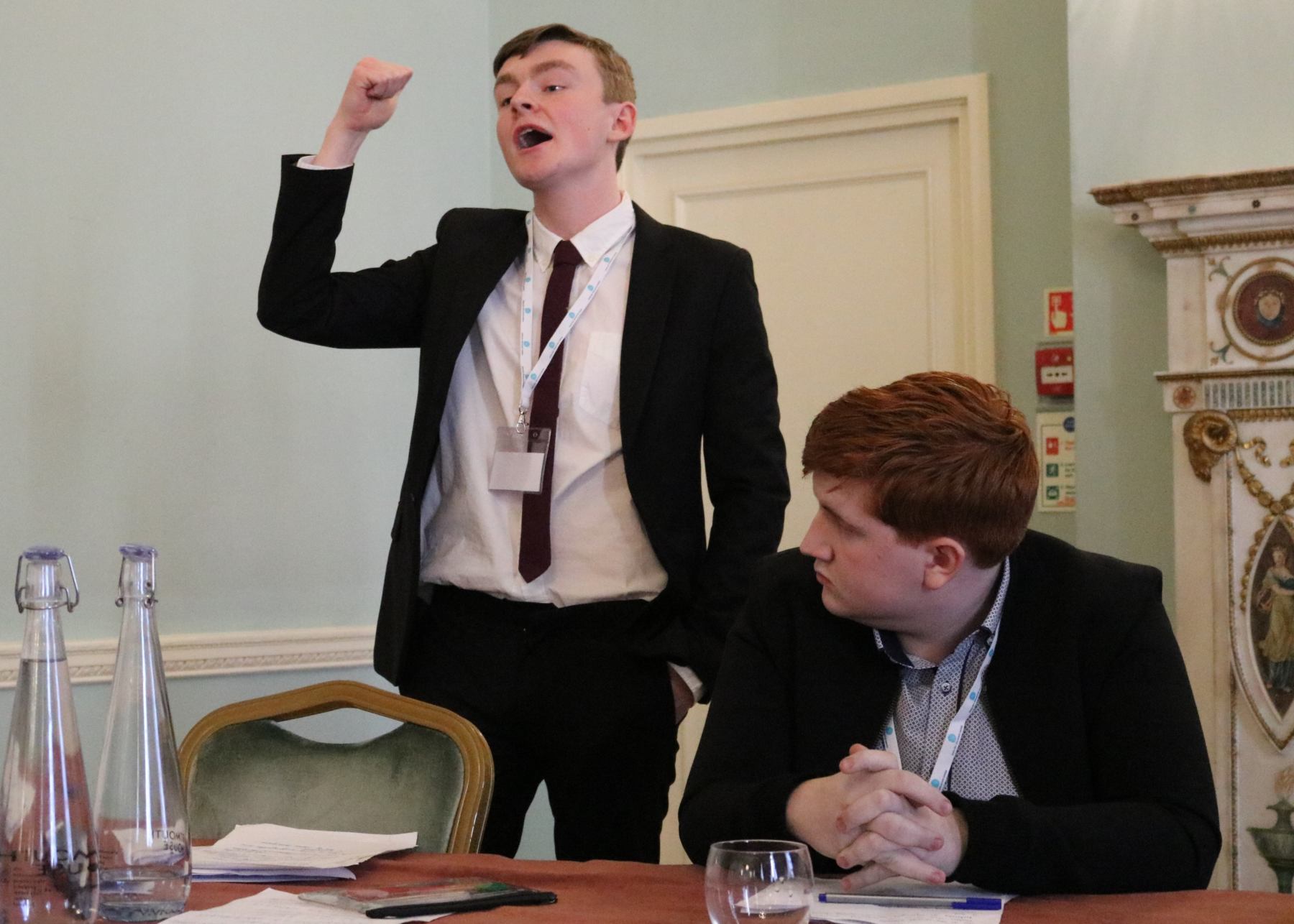 A pupil passionately delivers his speech while his team mate carefully watches