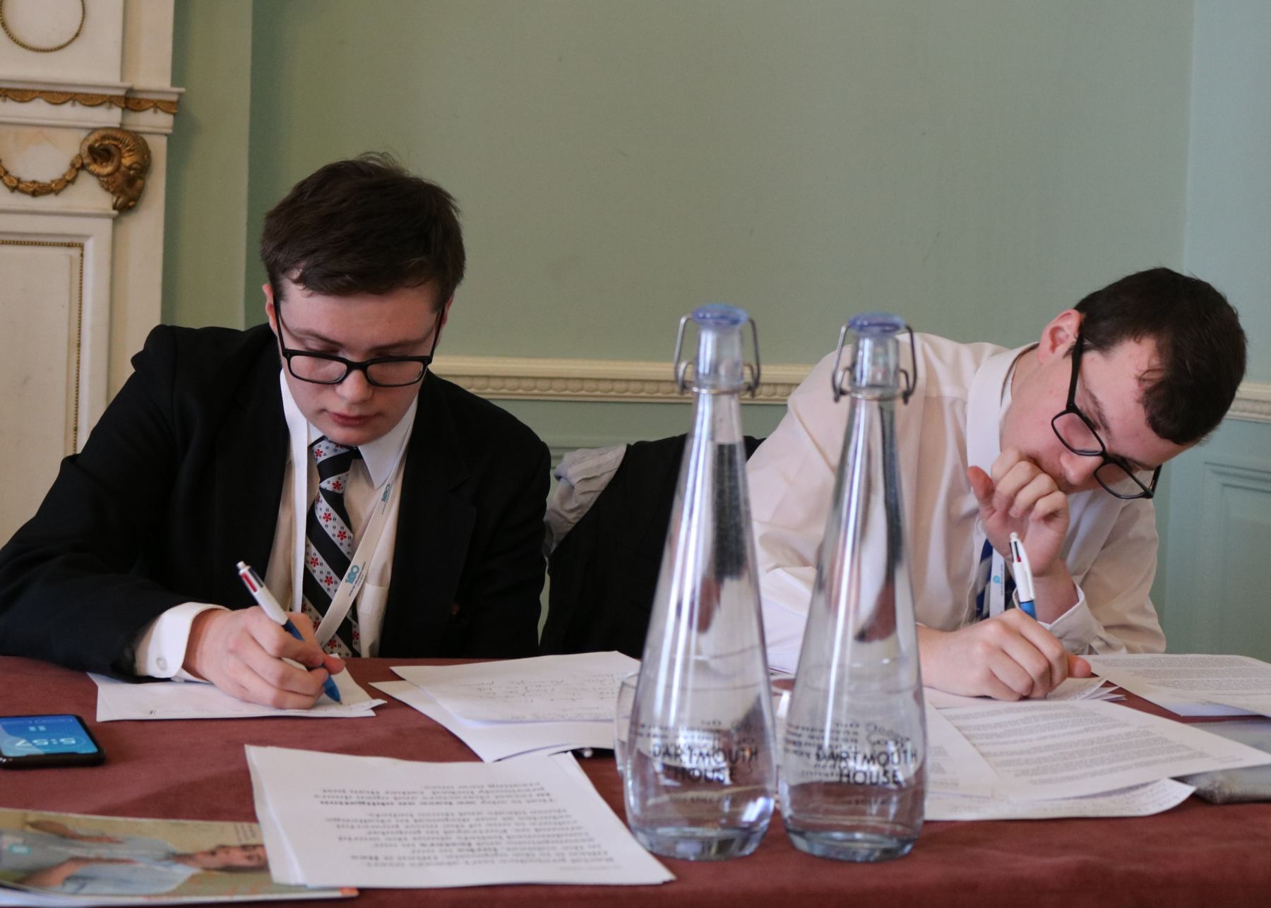 Two pupils writing their notes for their debate