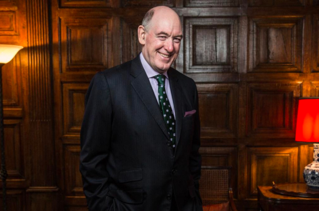 Photograph of Miles Young, wearing a dark suit and smiling
