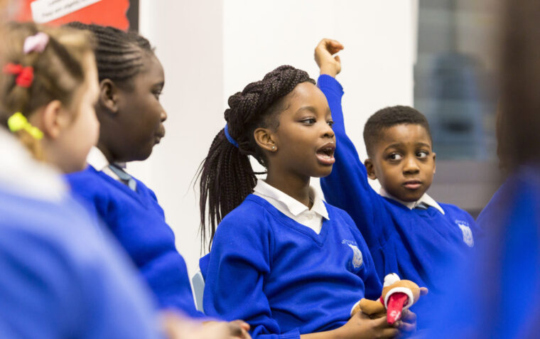 A small group of students speaking and listening to each other in a classroom