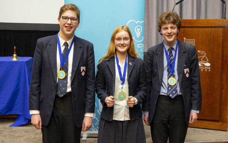Young pupils posing with the medals and trophy won